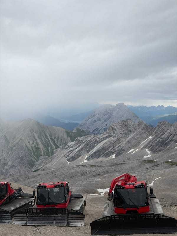 Zugspitze summit: snow groomers, church, and summer clouds