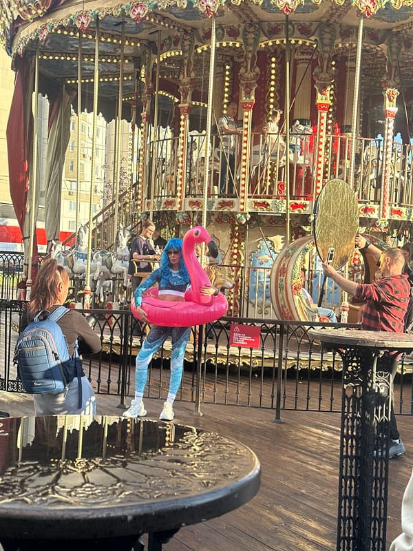 Pink flamingo float and blue hair on a Moscow boardwalk