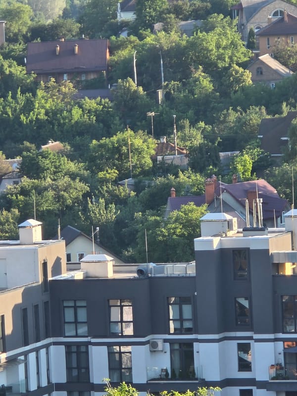 Balcony views over a green, dense residential neighborhood