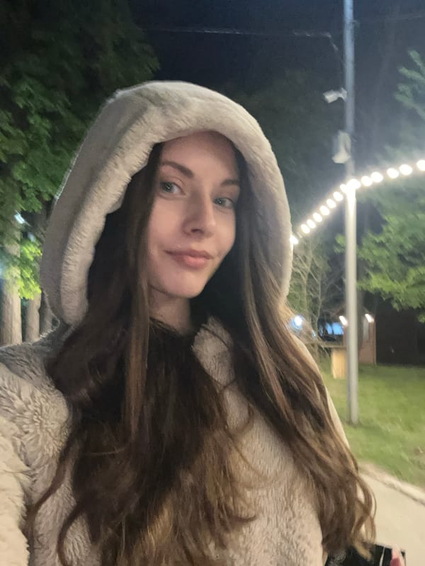 Woman photographed on illuminated nighttime pathway amid string lights