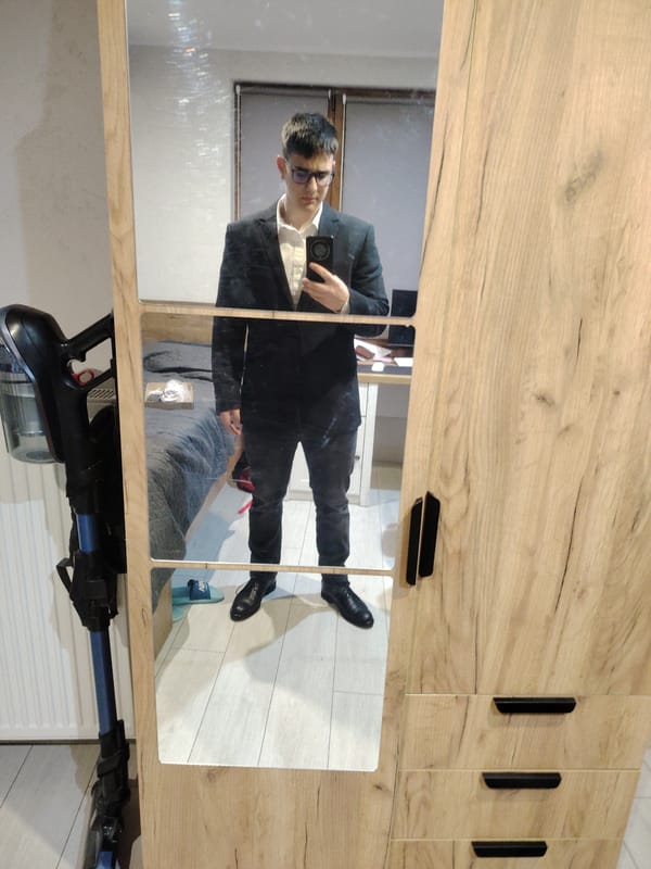 Person takes formal attire selfie in bedroom mirror