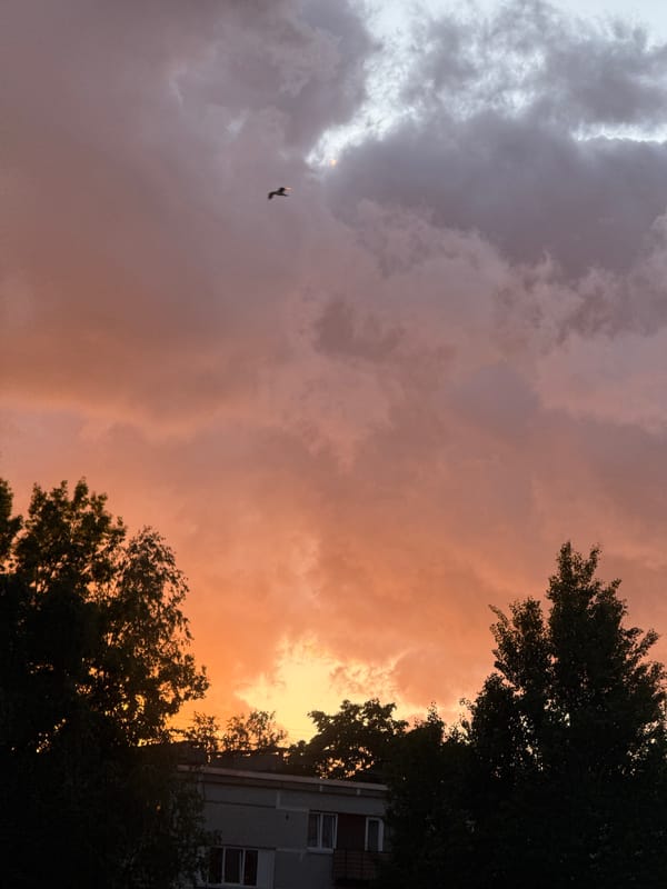Dramatic storm clouds contrast with sunset over Riga