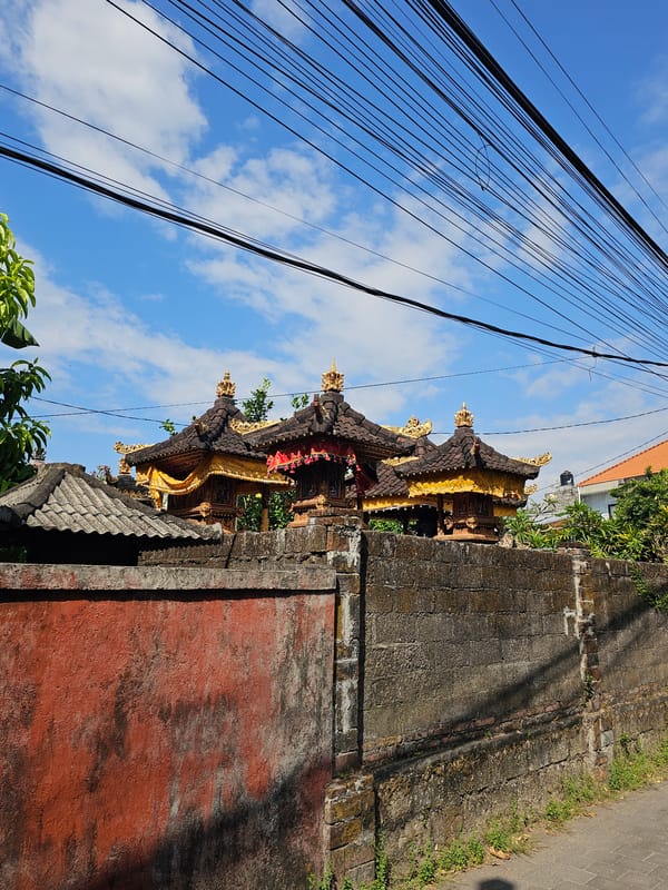 Morning delivery operations near traditional Balinese temple in Denpasar