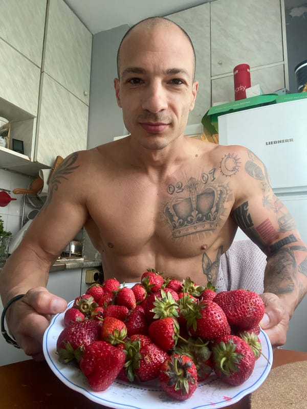 Tattooed man holds strawberries in Pleven kitchen
