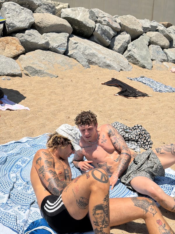 Tattooed beachgoers swimming and relaxing on Barcelona's coast
