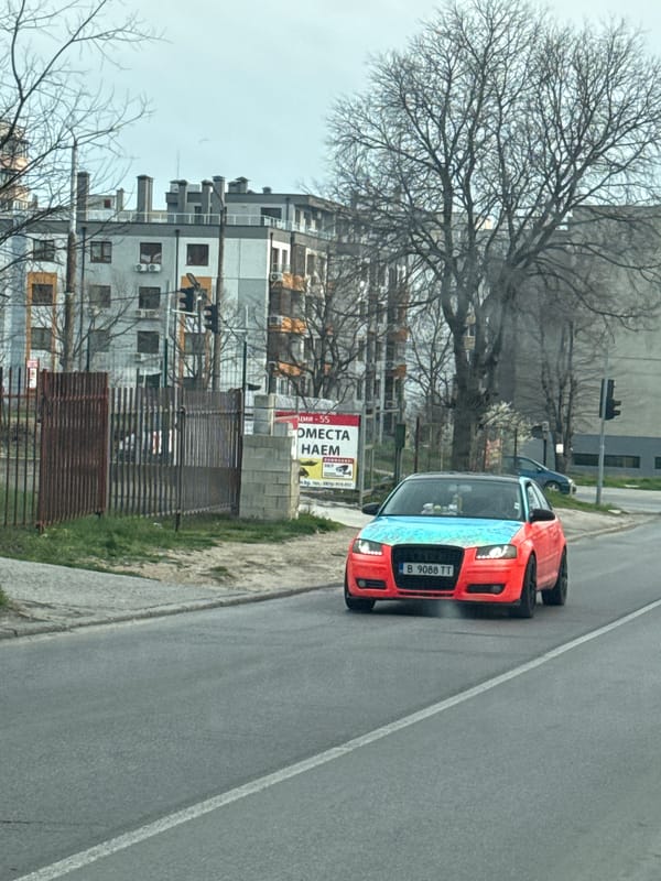Red Audi drives through residential street in Varna, Bulgaria