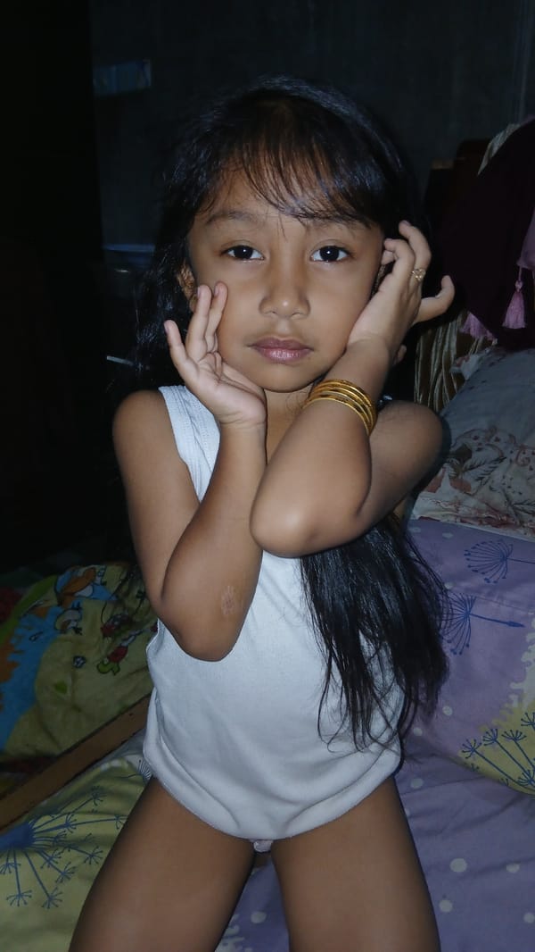 Resting on a bed, gold jewelry visible, Keudejungkagajah