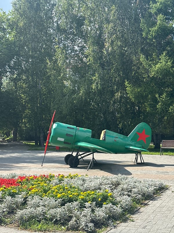 Park stroll past a display plane, cell tower, and street art