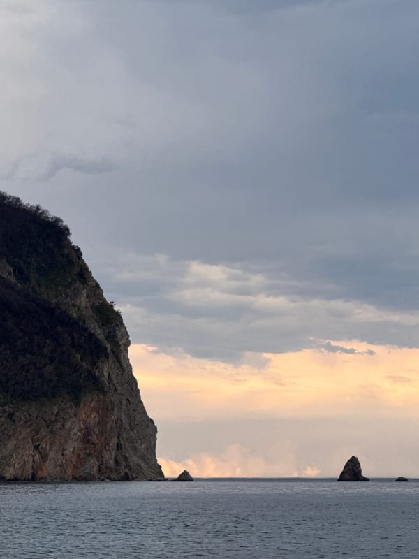 Overcast day at a rocky pebble beach with mountain backdrop