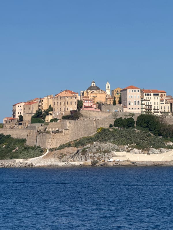 Coastal cliff town observed under clear morning skies