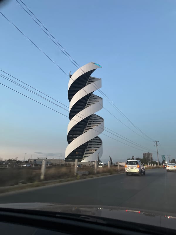 Sculptural pedestrian bridge observed from vehicle in Mexico