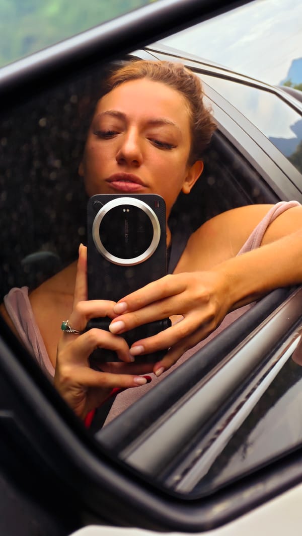 Woman takes selfie while traveling rural Vietnam road