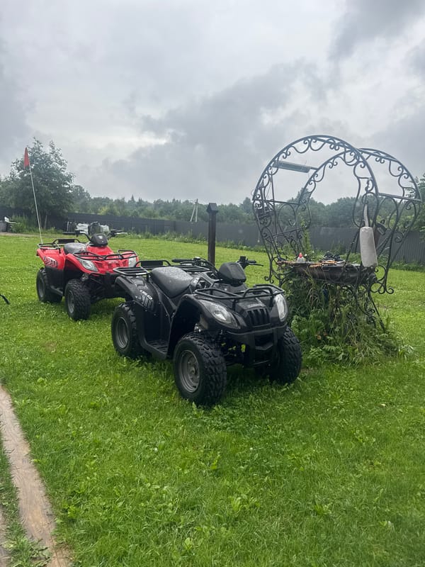 Two ATVs parked on a lawn in rural Russia