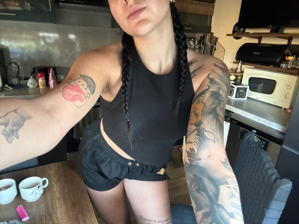 Tattooed woman documented in morning routine, Veliko Tarnovo kitchen