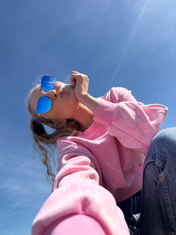 Person in pink hoodie photographed against blue sky in Chaykovsky