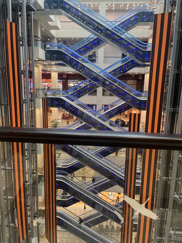 Inside a Russian shopping mall, escalators and red-lit floors