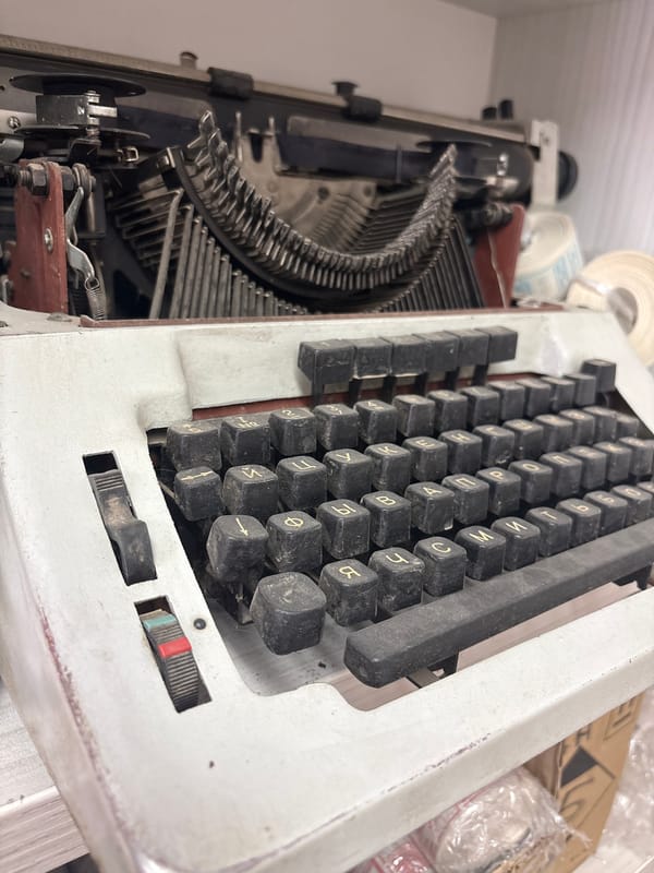 Woman documents vintage typewriter workspace in Russian office