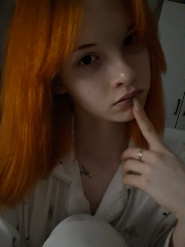 Orange-haired person photographed in low-light conditions