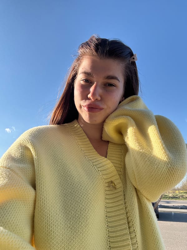 Woman in yellow sweater photographed against blue sky in Russia