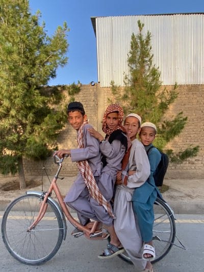 Four boys share single bicycle on Kandahar street
