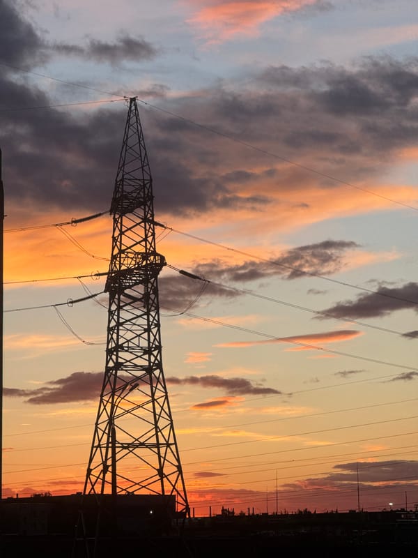 Evening sunset illuminates Minsk power infrastructure, resident walks nearby