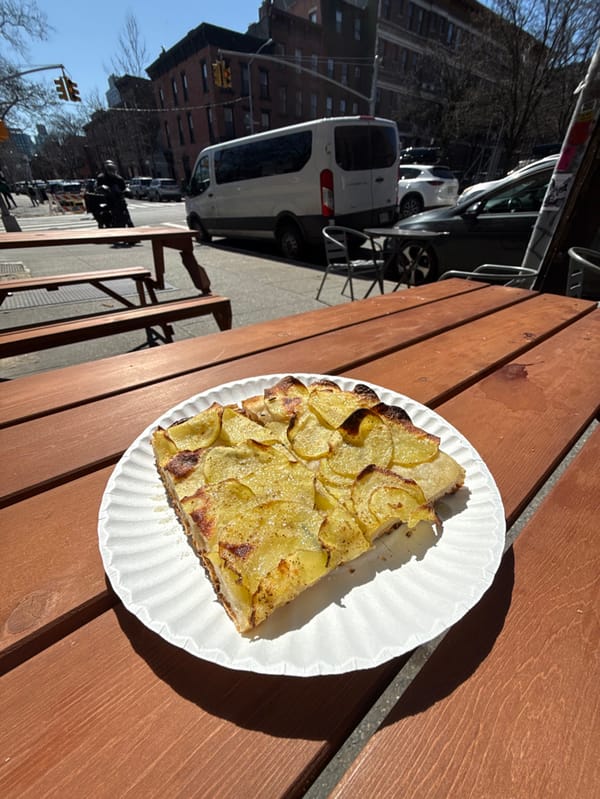 Customer enjoys potato tart at Impasto restaurant in NYC