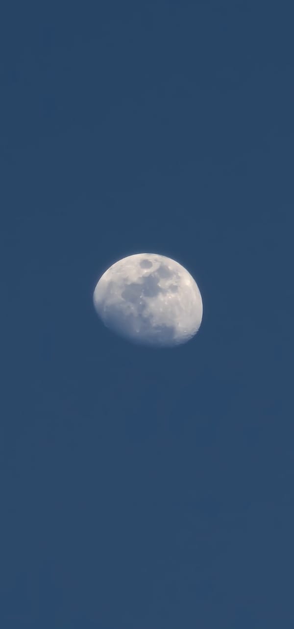 Moon, architecture, and poolside light in afternoon Doha