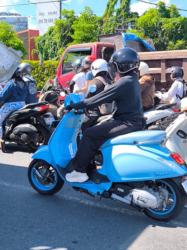 Traffic standstill captured with blue Vespa rider in Kuta