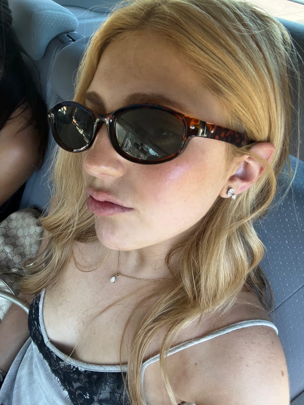 Woman rests in vehicle wearing sunglasses in Antibes