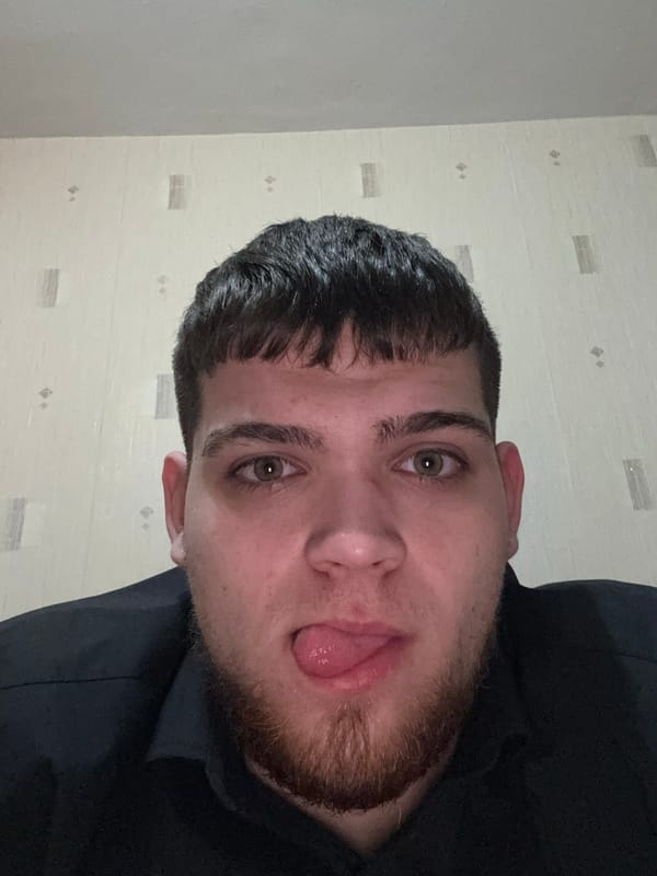 Man in black hoodie makes playful face indoors
