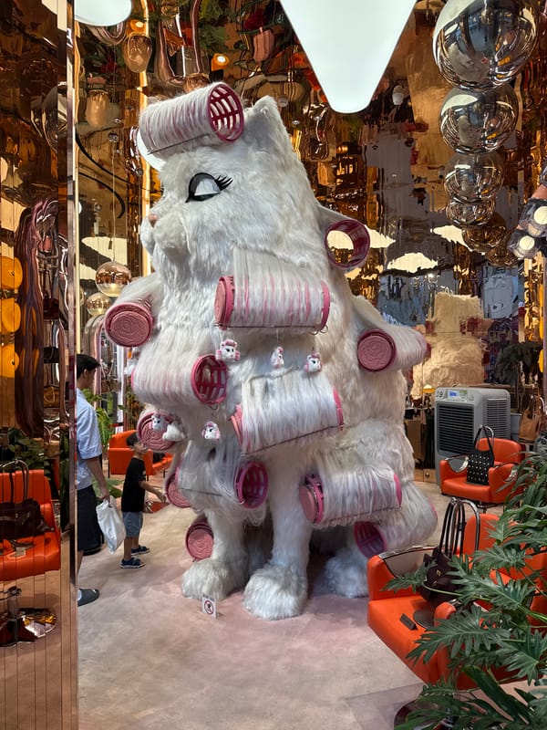 Oversized white cat sculpture with pink rollers in Bangkok retail display