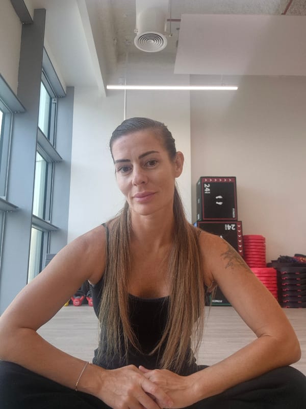 Woman exercises at gym with weights and skylight