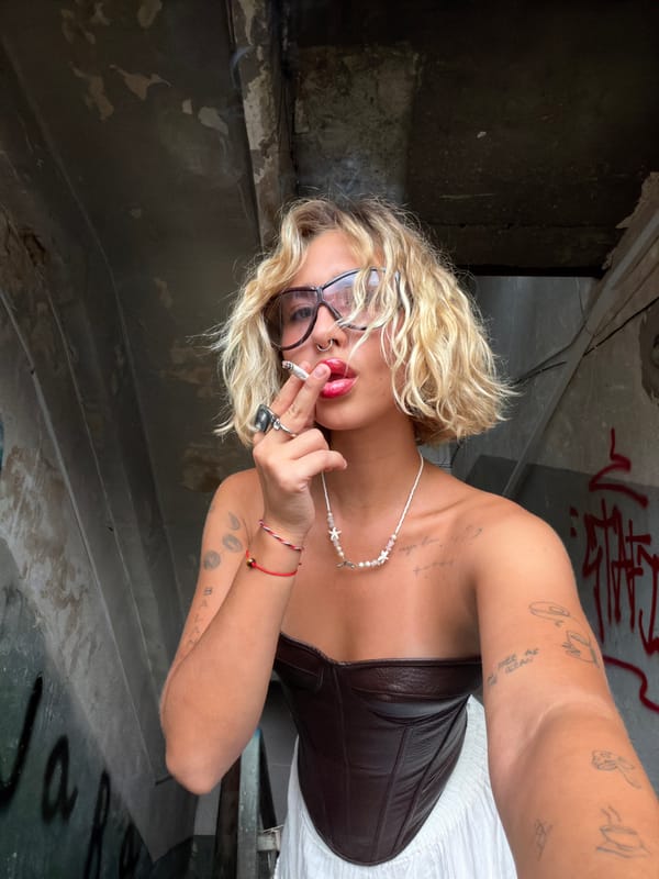 Posing in a ruined Tbilisi building, corset and cigarette in hand