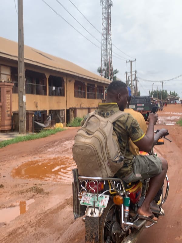 Motorcycle navigates flooded road in Nsugpe, Nigeria