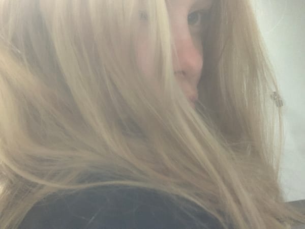 Blonde person photographed with artificial flowers in Sinyavino