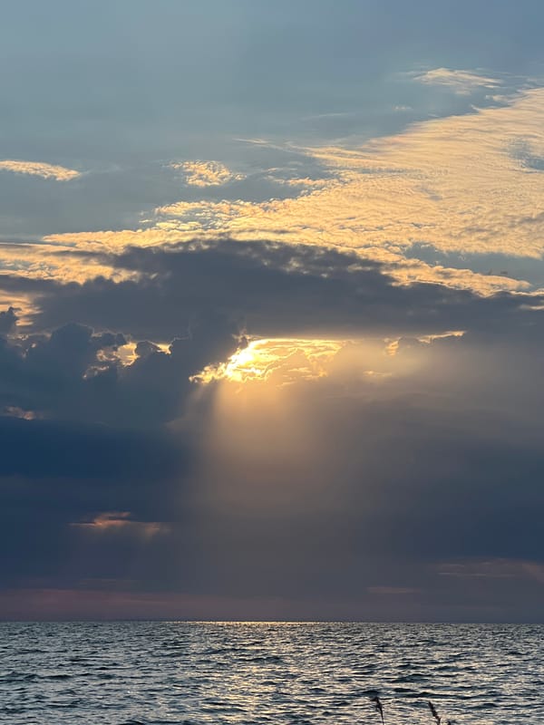 Sunbeams break through storm clouds over Lake Borovoe at dusk