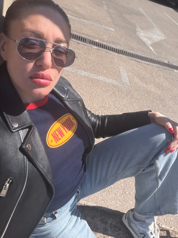 Person in New York shirt rests on pavement in Bar