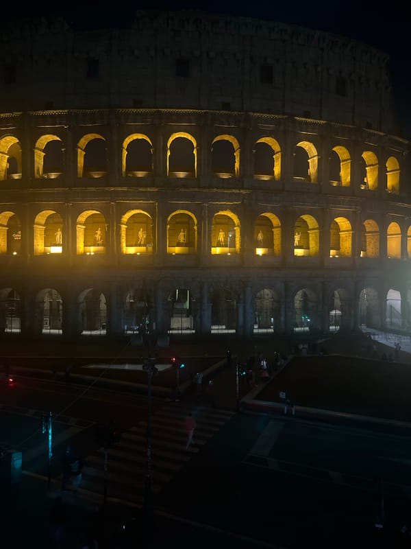 Evening tourists capture illuminated Colosseum during Rome nighttime visits