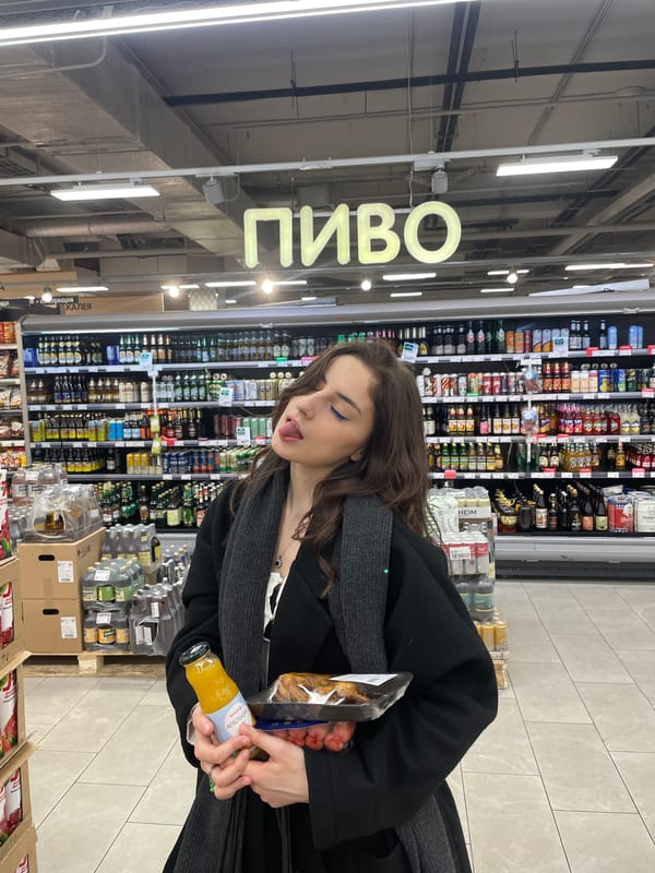 Woman shopping for orange juice in supermarket aisle