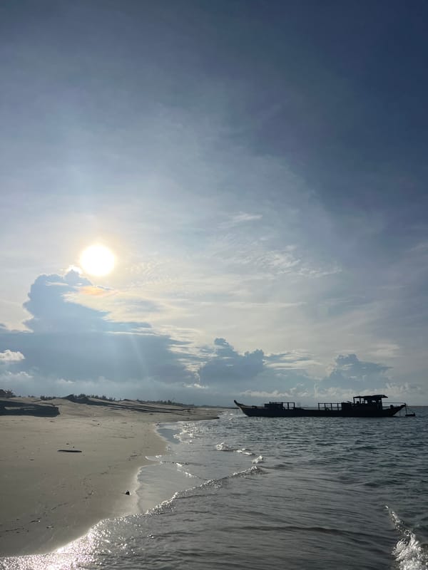 Hoi An coastline: boats, dunes, and offshore dredging on a cloudy morning