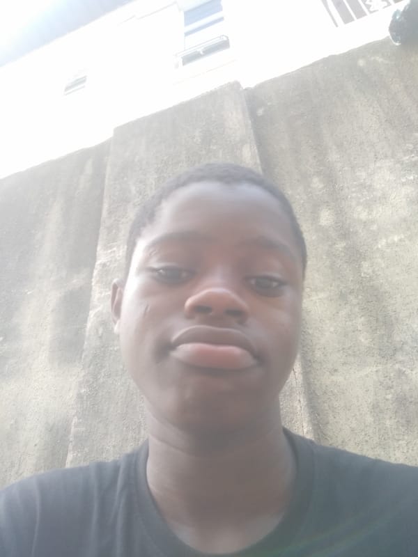 Person stands by wall in Shangisha, Nigeria