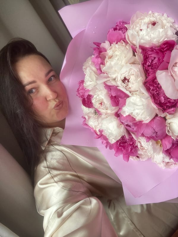 Woman poses with peony bouquet in Sochi bedroom