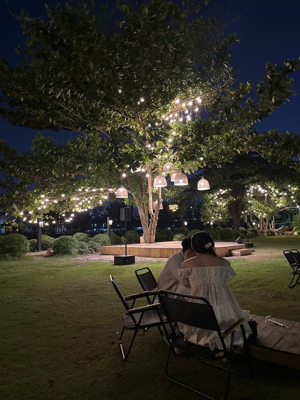 Woman dines at illuminated outdoor cafe in Ho Chi Minh City