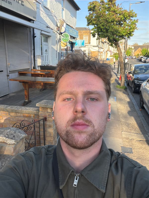 Individual takes selfie on sunlit London street Thursday evening
