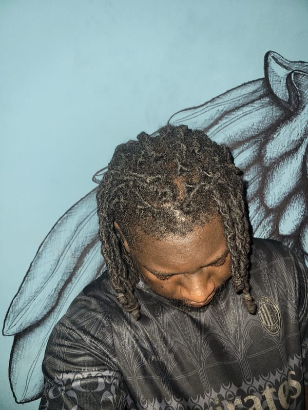 Person rests near wing artwork in Markurdi indoor space
