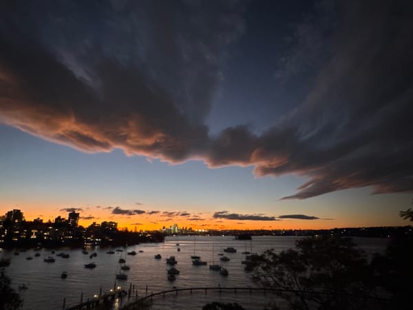 Sydney harbour glows under a dramatic dusk sky