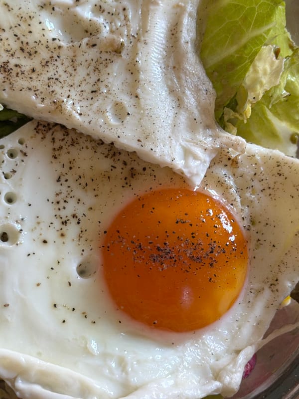 Fresh salad with fried eggs photographed in Catania