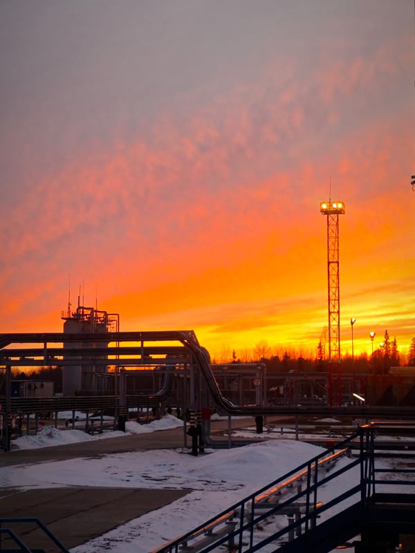 Russian industrial facility towers illuminated at sunset