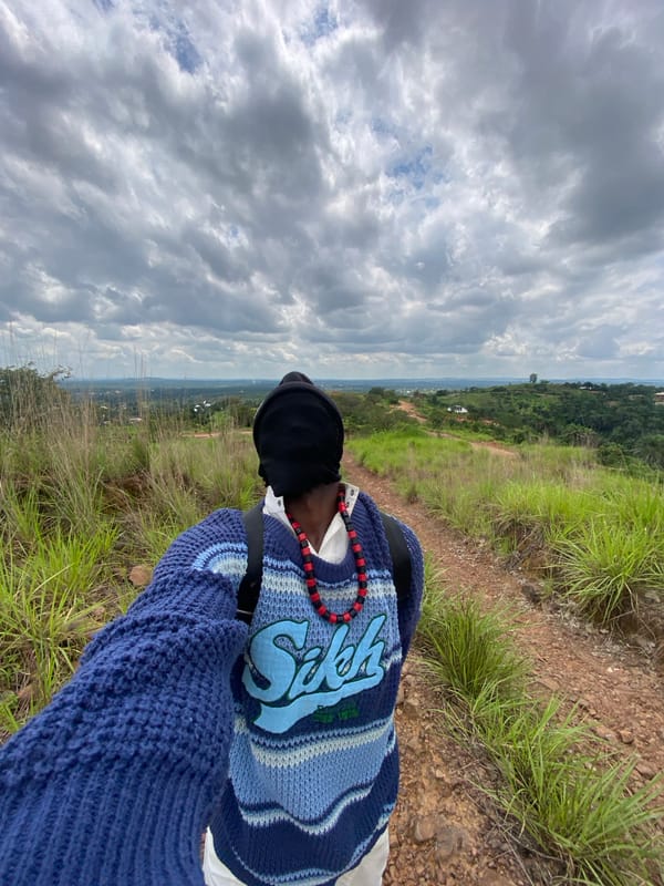Pausing on a dirt path in Nigeria's hilly countryside