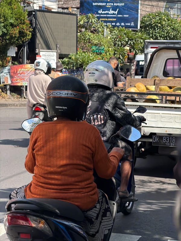 Motorcycle riders cruising through North Kuta on a sunny day